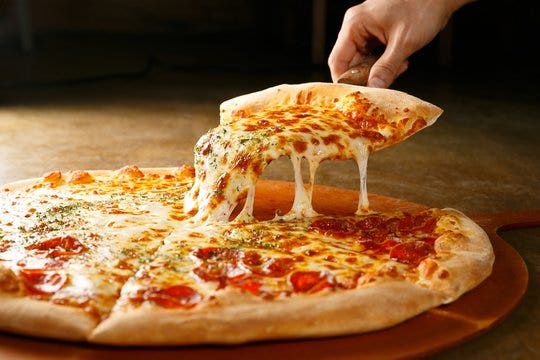 An image of a slice of pizza being lifted.